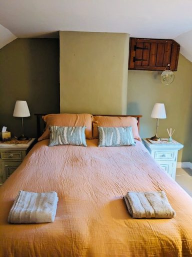 King size bed with natural bedding Main bedroom with king size bed, natural cotton muslin bedding, decorative pillows, bedside lights.